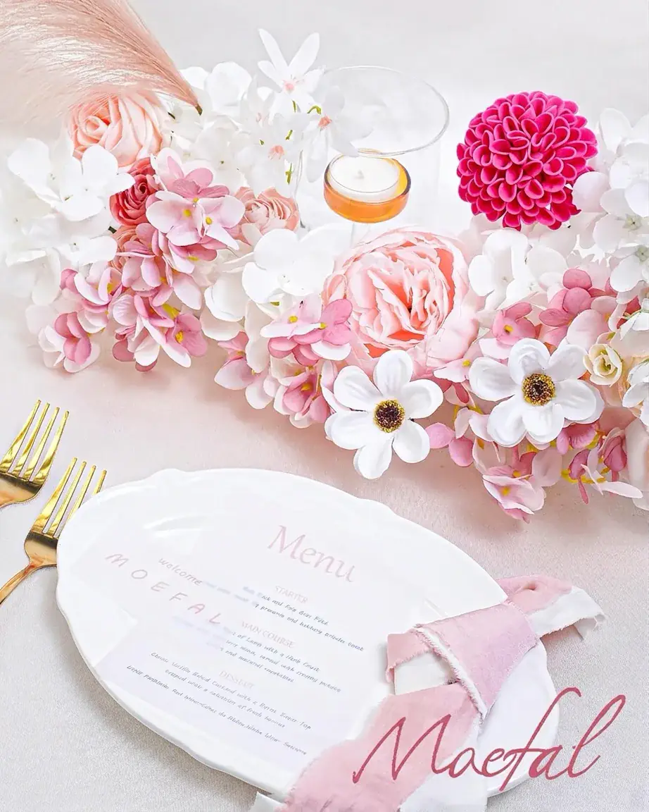 An elegant wedding tablescape featuring a centerpiece with dusty rose foam roses and hydrangeas.