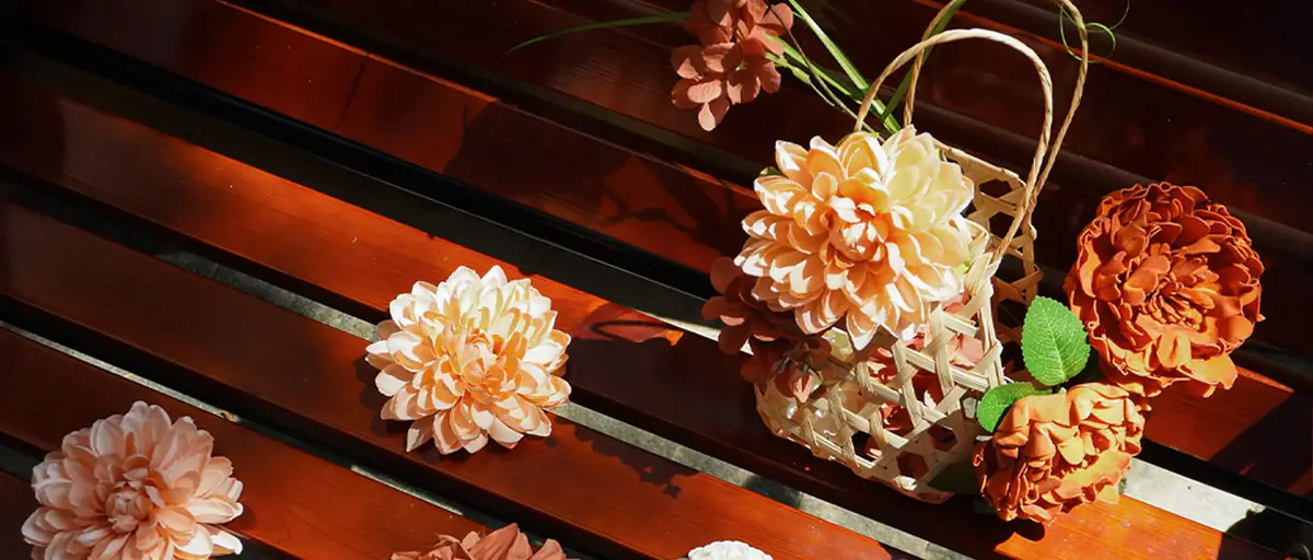 MOEFAL autumn new arrivals: terracotta and peach artificial dahlias and peonies with a woven basket on a sunlit wooden bench