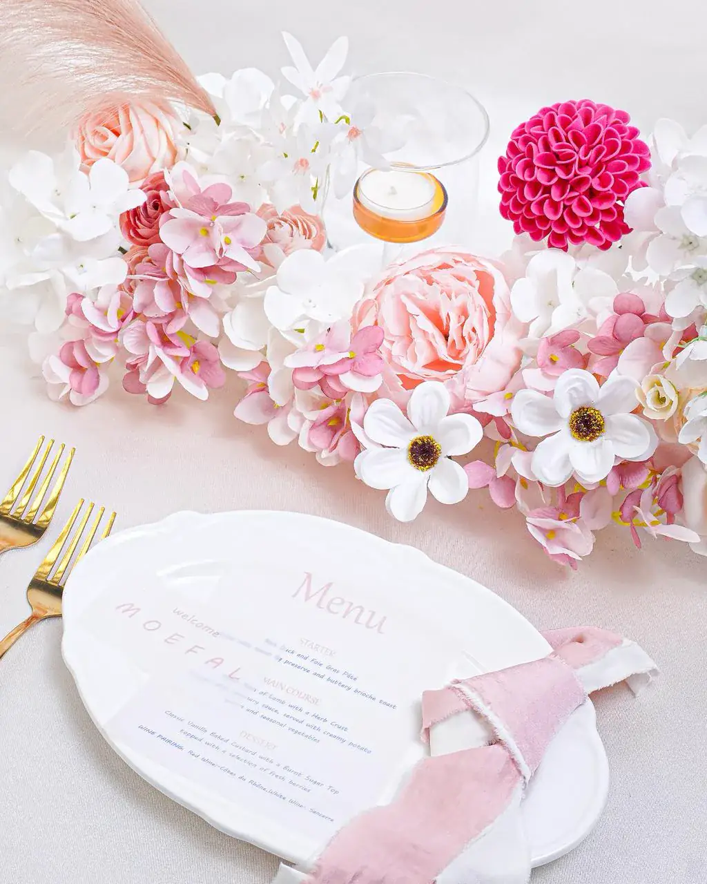 Pink and blush flower box centerpiece on a wedding place setting with a hot pink dahlia and menu card