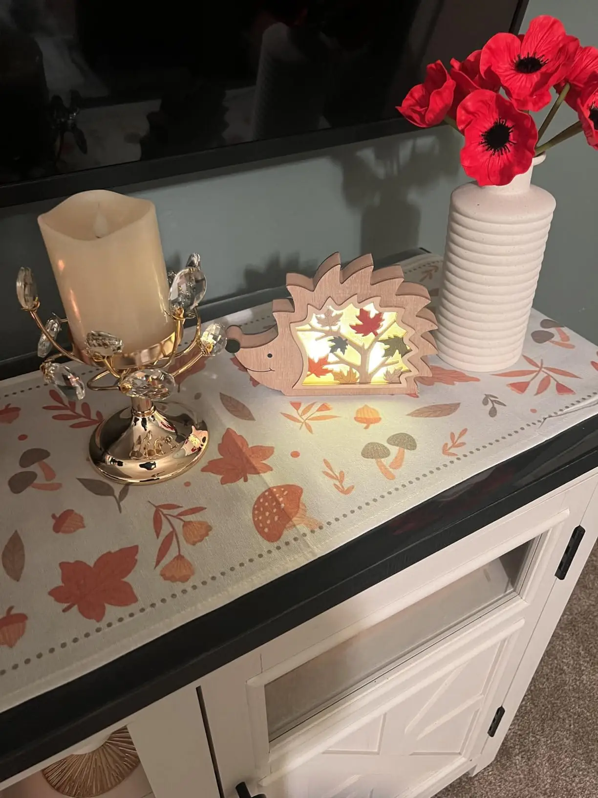 Red anemone poppies in a white ribbed vase on a cabinet