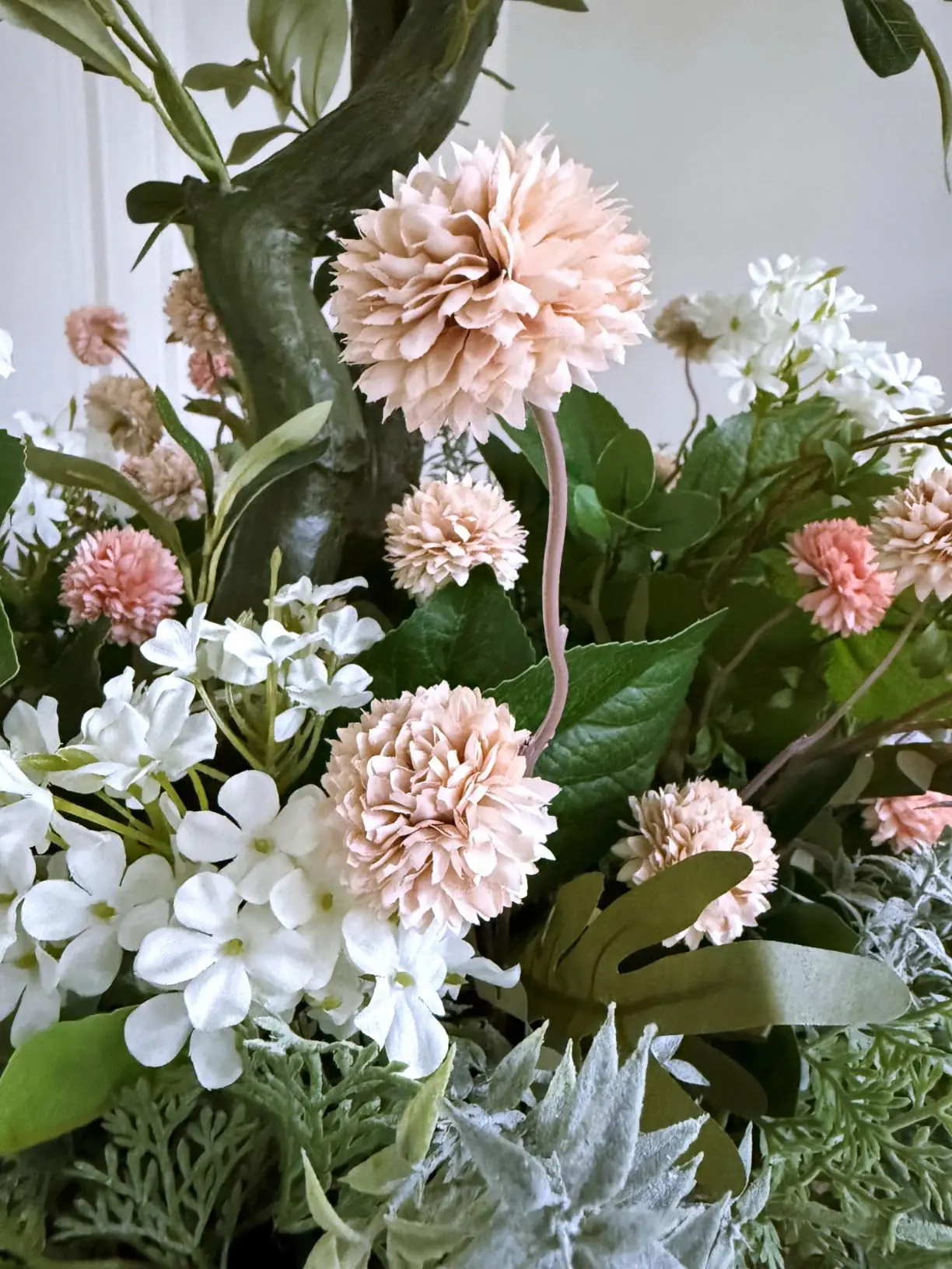Beige pompon mums with pink blooms, white lilac and greenery in an outdoor planter, customer photo