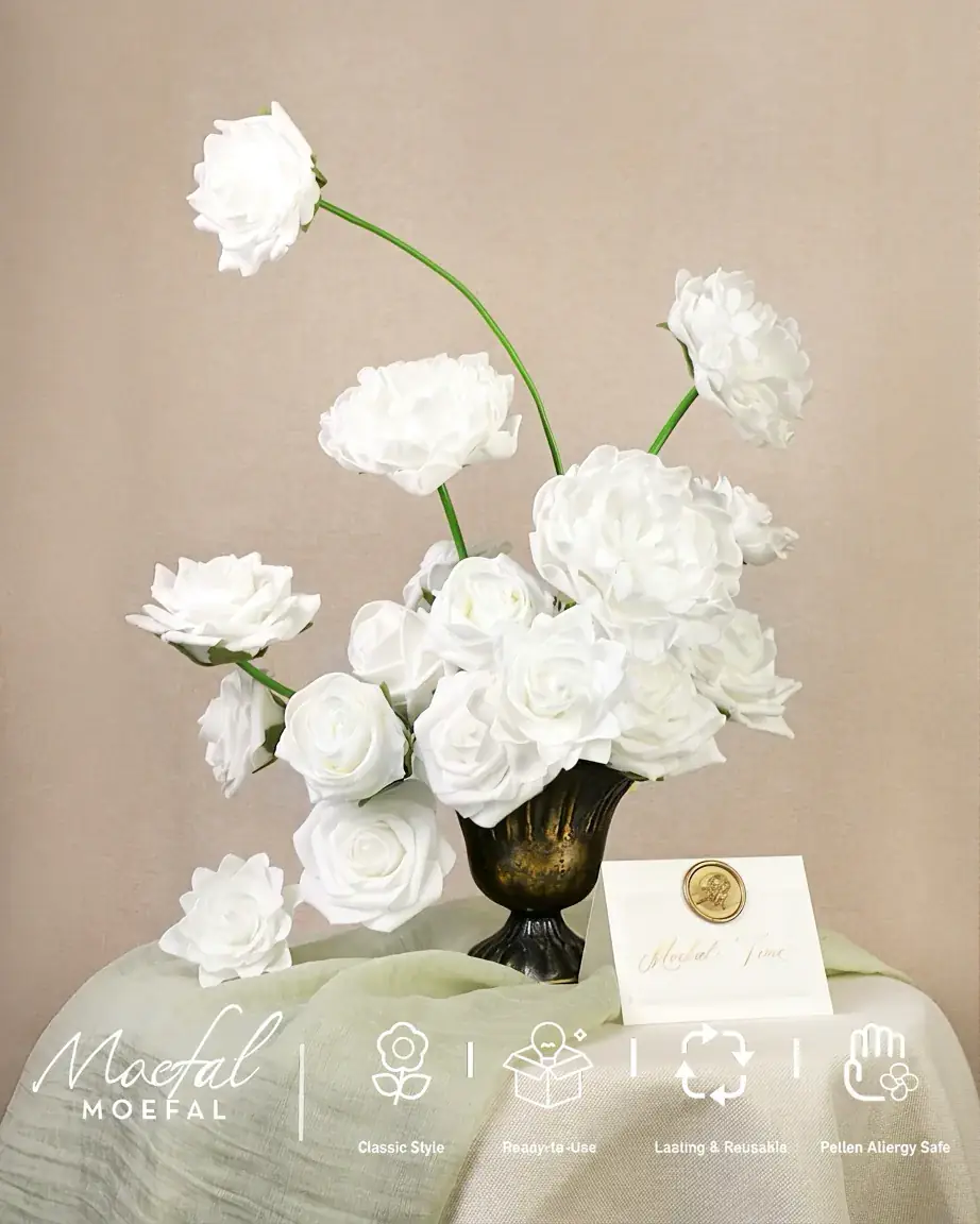 A lush faux arrangement of white peonies and roses in a dark vintage vase.