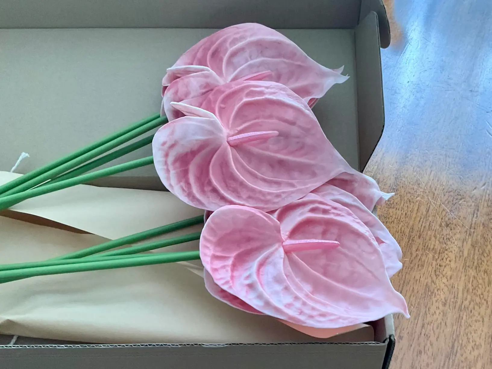 Blush pink artificial anthurium stems in an open MOEFAL box