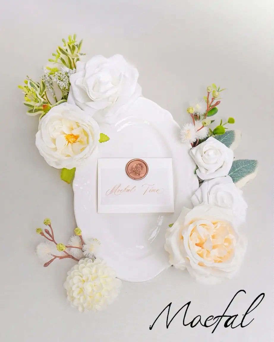 A flatlay of an ivory and sage wedding place setting with loose florals.