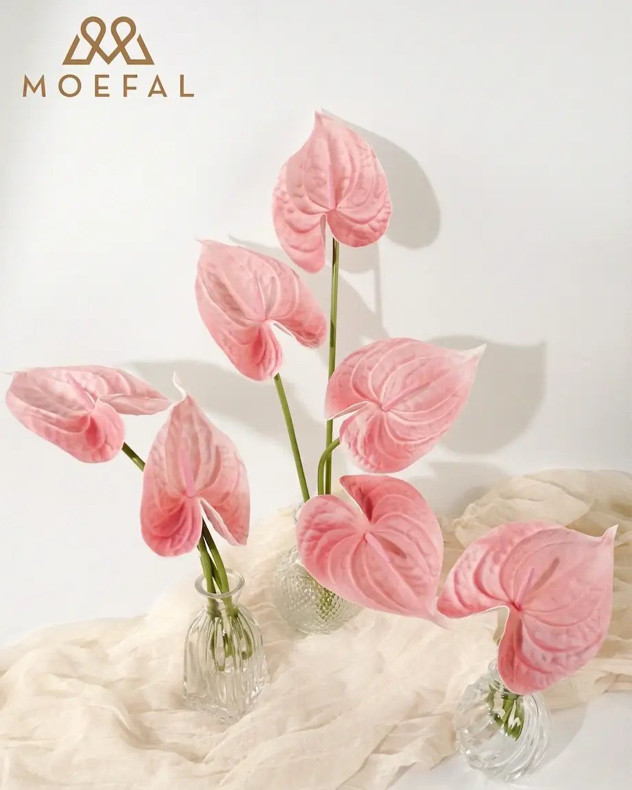 Blush pink artificial anthurium stems styled in small glass bud vases