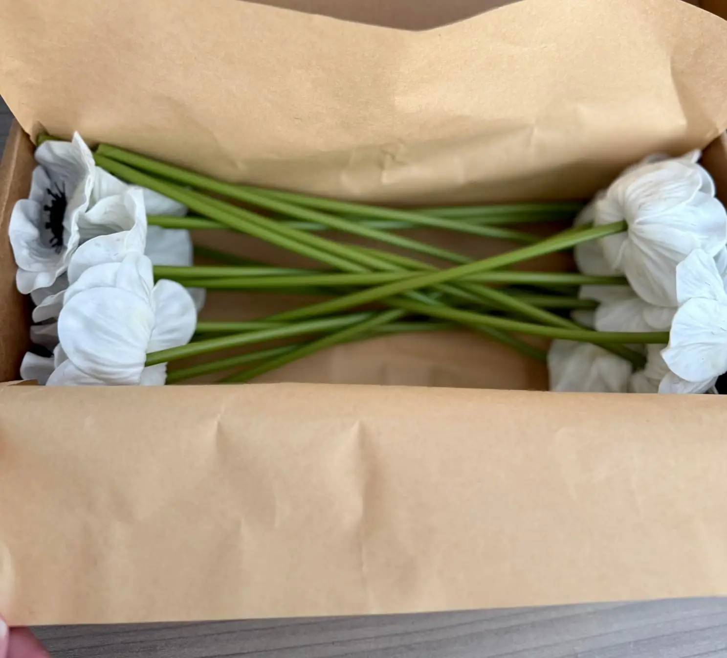 Open shipping box with kraft wrap and the MOEFAL tag