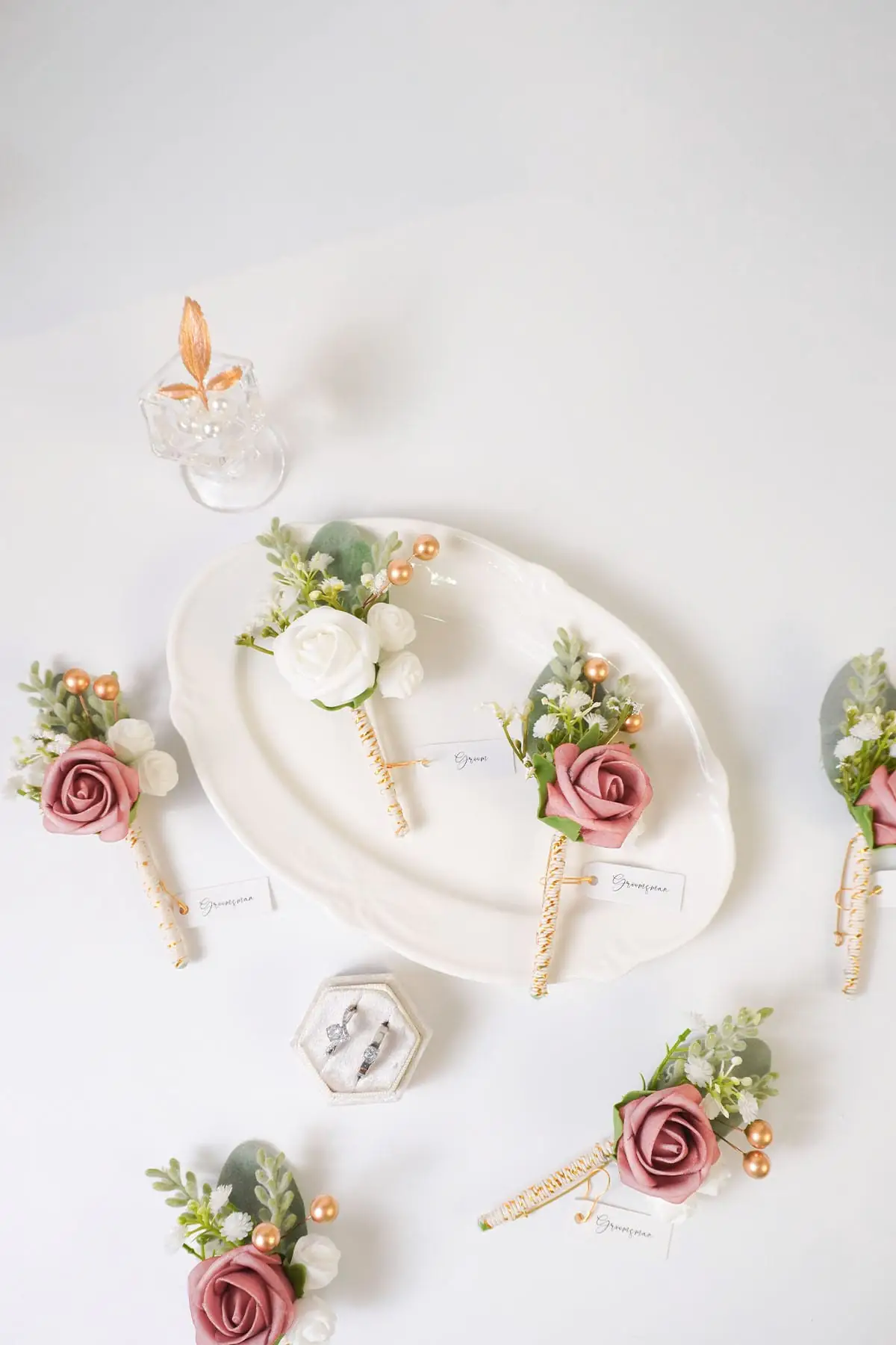 Dusty rose boutonniere set with faux roses for groom and groomsmen wedding attire