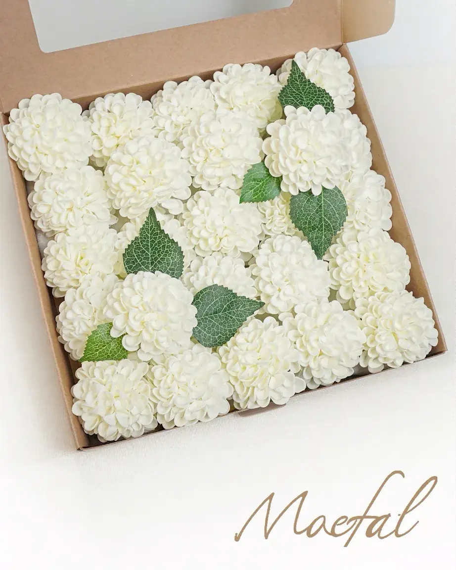 Top-down view of a box filled with ivory dahlia heads for wedding flowers.